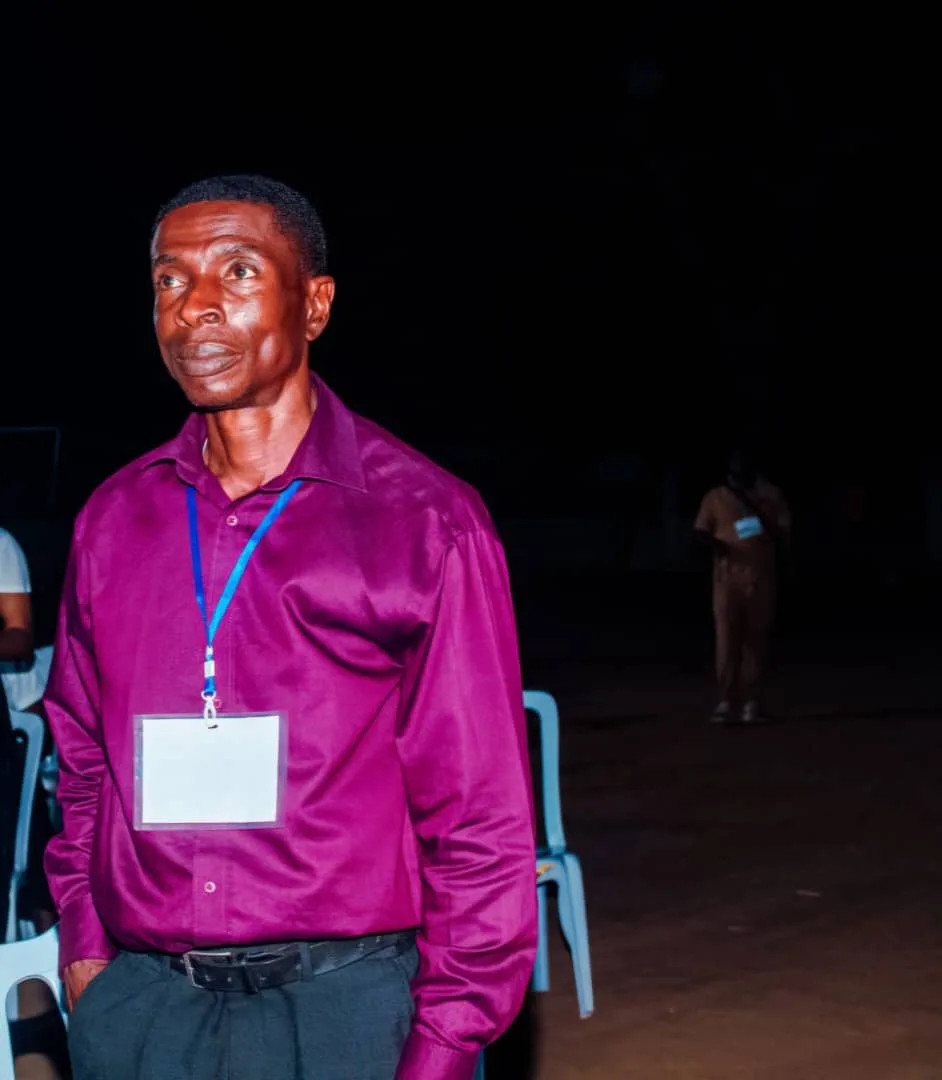 Evangelist Emeka Nwoko standing in a magenta shirt with an event lanyard