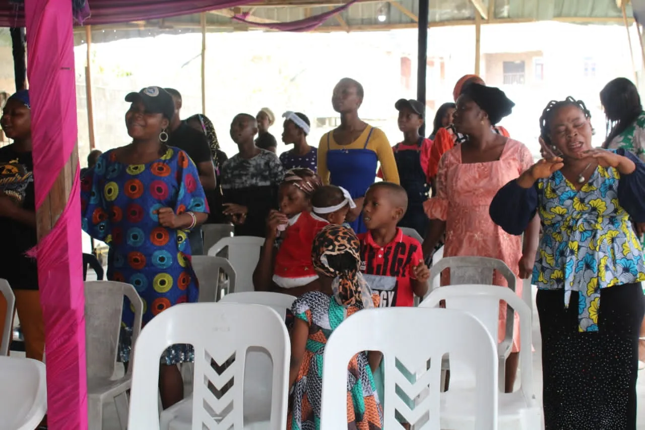 Women and children seated under the canopy at the summit