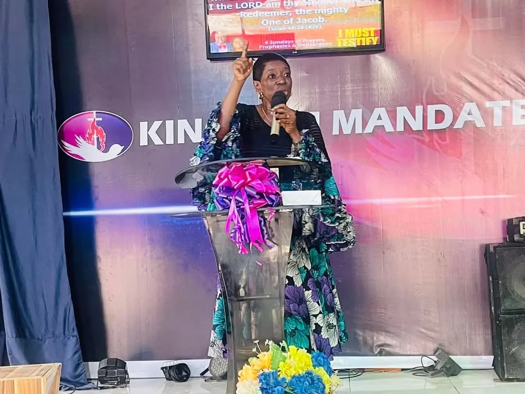 A minister preaching from the lectern with a scripture from Isaiah displayed on the screen behind