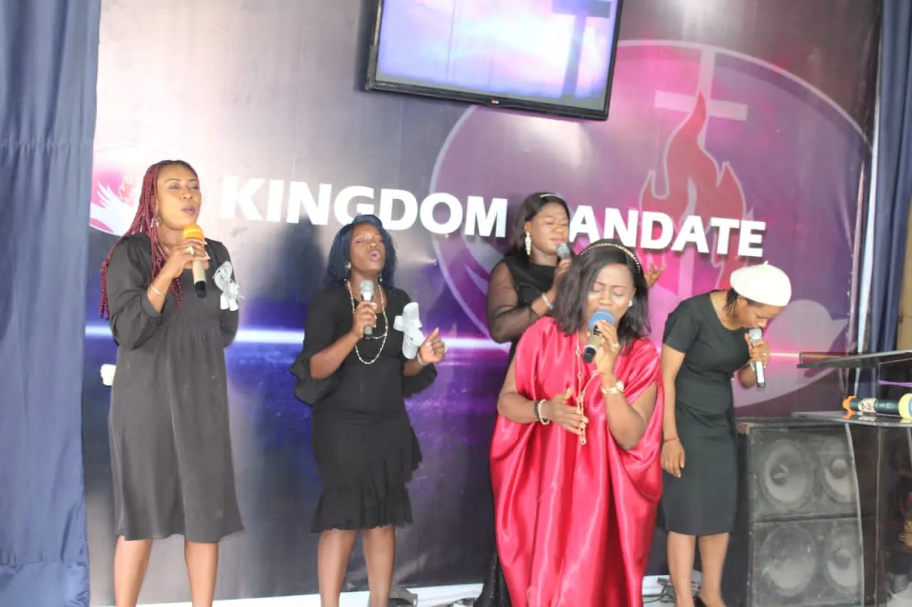 Four ministers leading worship together with handheld microphones