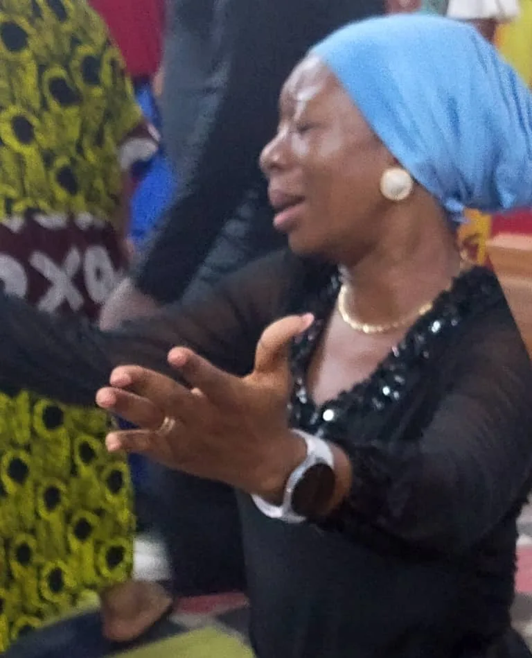 A member interceding with open hands during a prayer gathering