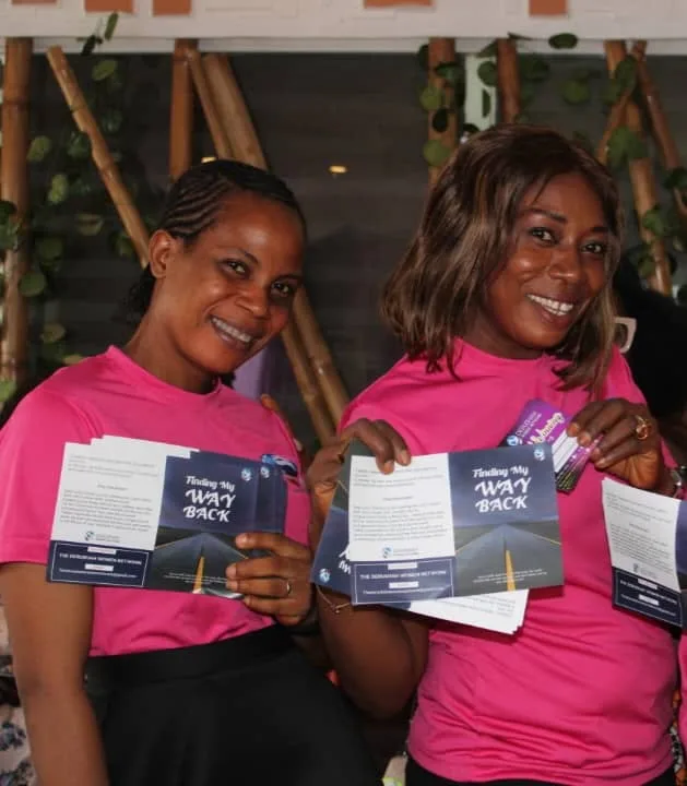 Two members holding “Finding My Way Back” evangelism tracts