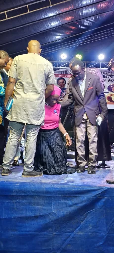 Ministers laying hands in prayer on stage at a prayer summit